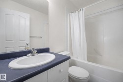 Bathroom vanity with an integrated sink, chrome faucet, and dark countertop - 