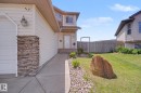 Exterior facade featuring light-colored horizontal siding and a stone-clad column - 262 Dunvegan Road, Edmonton, AB 