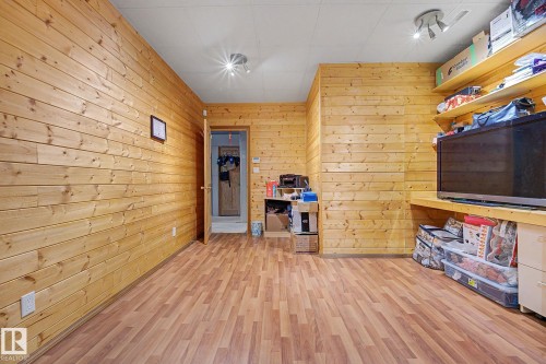 Interior room featuring wood plank wall paneling, wood-finish flooring, a suspended ceiling, and built-in shelving - 262 Dunvegan Road, Edmonton, AB 