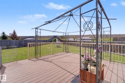 Spacious outdoor deck with wood-finish decking and a metal gazebo frame - 