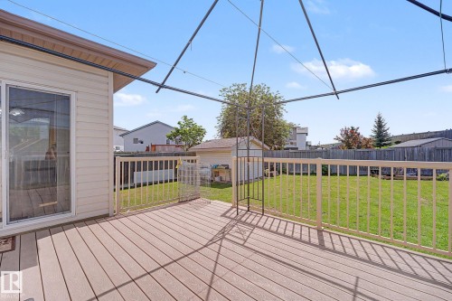 Spacious exterior deck with composite decking and white railings, featuring direct access via a sliding glass door - 262 Dunvegan Road, Edmonton, AB 