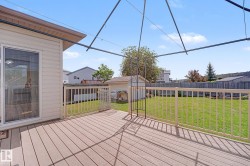 Spacious exterior deck with composite decking and white railings, featuring direct access via a sliding glass door - 