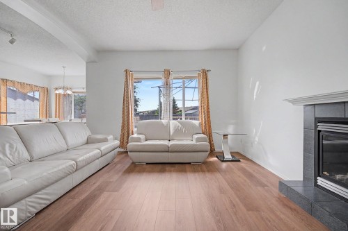 Living area featuring wood-finish flooring and a tiled fireplace with a mantel - 262 Dunvegan Road, Edmonton, AB 