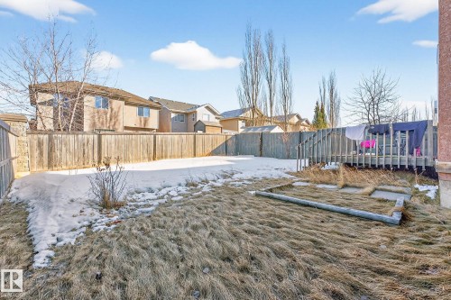 Yard layered in snow with a fenced backyard and a residential view - 1660 Malone Way, Edmonton, AB 