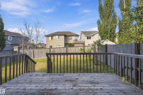 Expansive wood deck with railing, leading to a green lawn with a privacy fence - 1660 Malone Way Nw, Edmonton, AB 