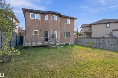 Expansive backyard featuring a large wooden deck with stairs, a wooden privacy fence, and a stucco exterior - 1660 Malone Way Nw, Edmonton, AB 
