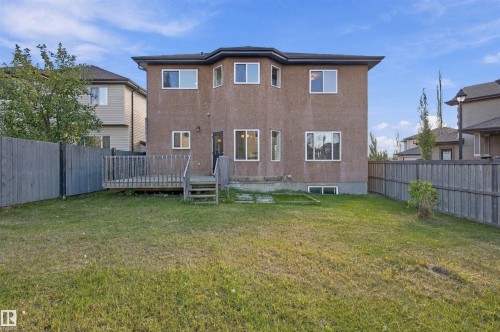 Expansive backyard featuring a wooden privacy fence, a multi-level wooden deck, and a stucco exterior - 1660 Malone Way Nw, Edmonton, AB 