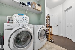 Laundry area with washing machine and dryer and light tile patterned floors - 