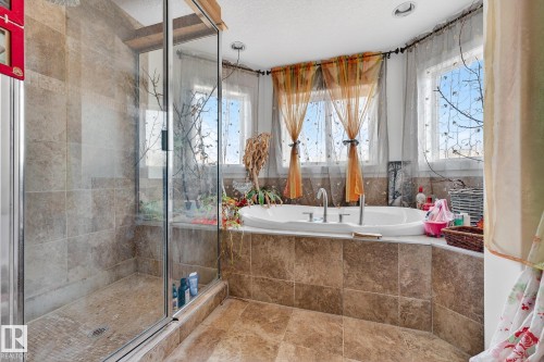 Bathroom featuring a stall shower, a garden tub, and a textured ceiling - 1660 Malone Way, Edmonton, AB 