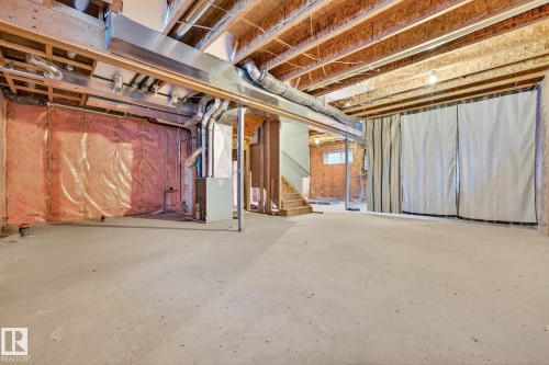 Unfinished basement featuring stairway and heating unit - 1660 Malone Way, Edmonton, AB 