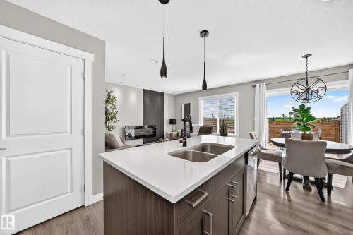 Kitchen island featuring a dual stainless steel sink and matte black faucet - 93 Richmond Link, Fort Saskatchewan, AB 