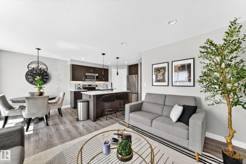 Open-concept living space featuring wood-finish flooring, recessed lighting, and a neutral wall palette - 93 Richmond Link, Fort Saskatchewan, AB 