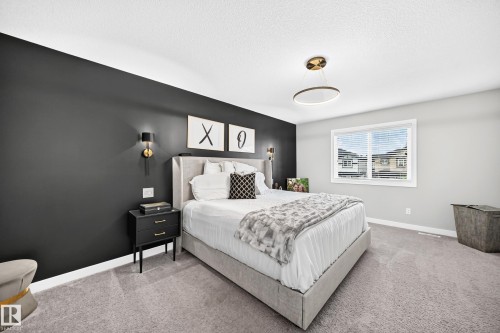 Bedroom featuring a dark accent wall, a single window with blinds, and light gray carpeting - 93 Richmond Link, Fort Saskatchewan, AB 