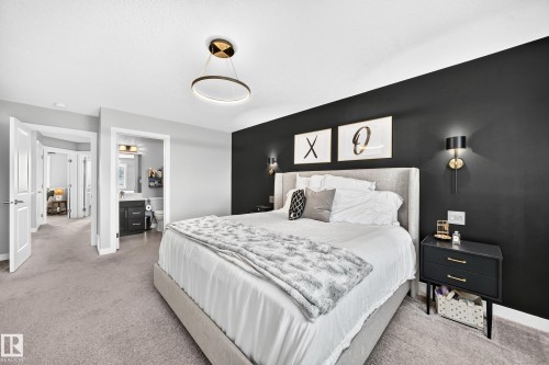 Bedroom featuring a dark accent wall, recessed lighting, and a contemporary ceiling fixture - 93 Richmond Link, Fort Saskatchewan, AB 
