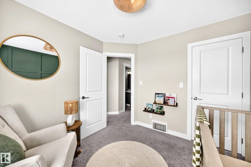 Neutral wall palette with contrasting accent wall featuring decorative trim - 93 Richmond Link, Fort Saskatchewan, AB 