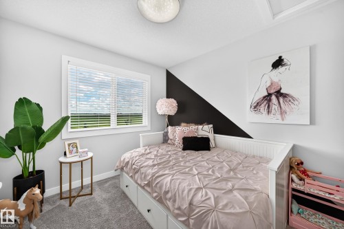 Bedroom featuring a large window with white blinds, light gray wall color, and a partial black accent wall - 93 Richmond Link, Fort Saskatchewan, AB 