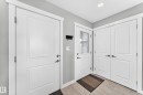 Entryway featuring a solid panel door, a door with a window pane, and double panel doors - 93 Richmond Link, Fort Saskatchewan, AB 