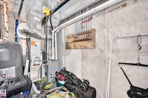 Utility area featuring a water heater, furnace, and a radiant heating manifold - 93 Richmond Link, Fort Saskatchewan, AB 