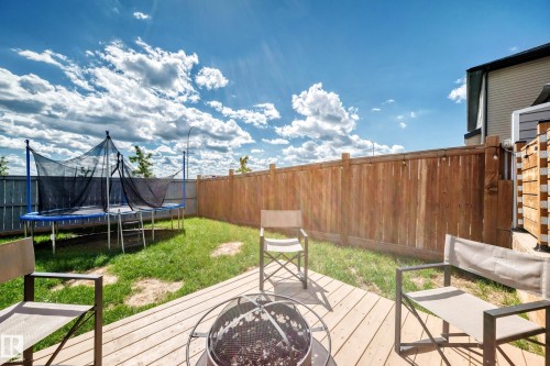 Backyard featuring a wood deck, fire pit, and privacy fencing - 93 Richmond Link, Fort Saskatchewan, AB 