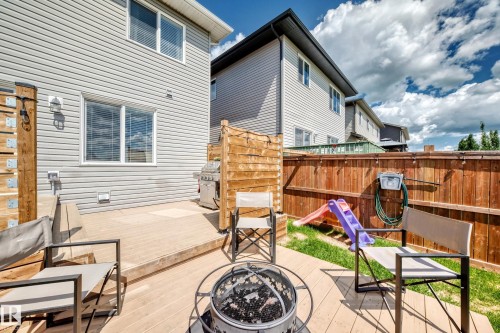 Backyard featuring a wood deck with a fire pit, a privacy screen, and a wood fence - 93 Richmond Link, Fort Saskatchewan, AB 