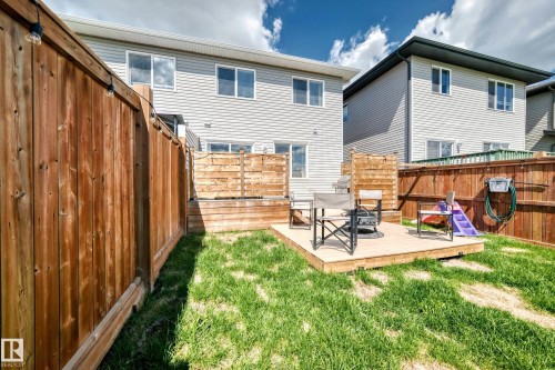 Backyard featuring a wooden privacy fence, a raised wooden deck, and a grass lawn - 93 Richmond Link, Fort Saskatchewan, AB 