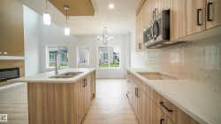 Kitchen island with dual stainless-steel sinks and a modern pull-down faucet - 