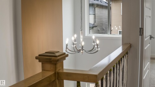 Staircase landing featuring a wood handrail and newel post - 3708 40 Ave, Beaumont, AB 