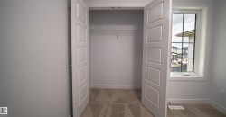 Bedroom featuring a spacious closet with bifold doors, wire shelving, and neutral carpeting - 