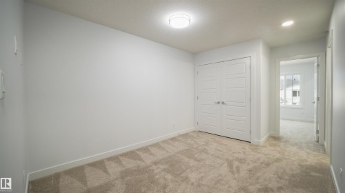Neutral-toned carpeting and light gray walls create a versatile interior space - 3708 40 Ave, Beaumont, AB 