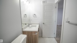Modern bathroom vanity with wood-finish cabinetry, white countertop, and an integrated rectangular sink - 