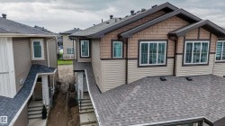 Exterior featuring a combination of horizontal siding and shake siding, white-framed windows, dark roof shingles, and brown trim accents - 