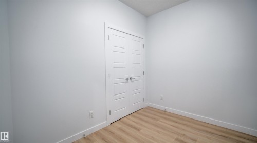 Bright interior featuring light-toned wood-finish flooring and crisp white walls - 3708 40 Ave, Beaumont, AB 