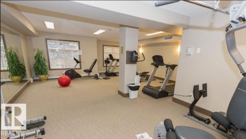 Dedicated fitness area featuring neutral carpeting, recessed lighting, expansive mirrored wall, and multiple windows with horizontal blinds - #141 11505 Ellerslie Rd, Edmonton, AB 