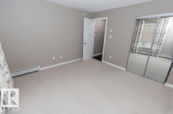 Carpeted room featuring a mirrored sliding closet door, neutral wall paint, white trim, and a white interior door - 