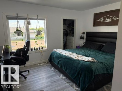 Bedroom featuring light wood-finish flooring and a window with white trim - 4917 45 Avenue, Vegreville, AB - Indoor Photo Showing Bedroom