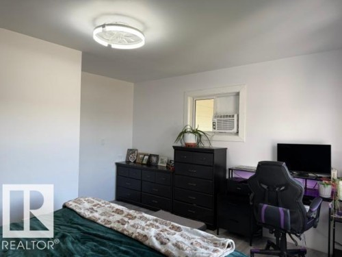 White walls and ceiling with a ceiling-mounted light fixture, window with a white frame, and light-colored flooring - 4917 45 Avenue, Vegreville, AB - Indoor Photo Showing Bedroom