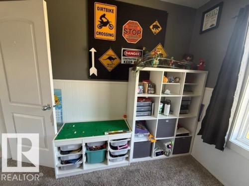 White interior door with chrome hardware, complemented by white wainscoting and dark gray upper wall paint - 4917 45 Avenue, Vegreville, AB - Indoor Photo Showing Other Room