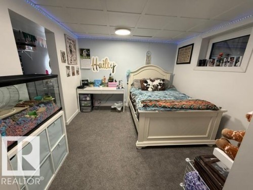 Carpeted room featuring a window with a deep sill, a white paneled ceiling, and recessed lighting - 4917 45 Avenue, Vegreville, AB - Indoor Photo Showing Bedroom