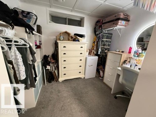 Carpeted room featuring built-in shelving, a small window, and a paneled ceiling - 4917 45 Avenue, Vegreville, AB - Indoor