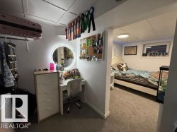 Carpeted interior space featuring a drop ceiling, white walls, and a window with a valance - 