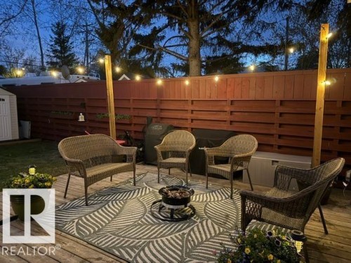 Wood deck patio featuring a decorative outdoor rug and string lighting - 4917 45 Avenue, Vegreville, AB - Outdoor With Deck Patio Veranda