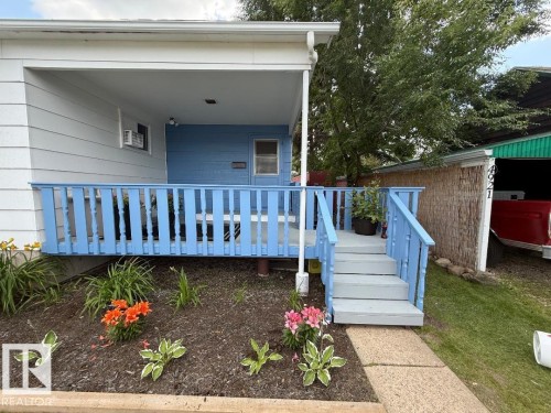 Covered porch with blue-painted railing and steps - 4917 45 Avenue, Vegreville, AB - Outdoor With Deck Patio Veranda With Exterior