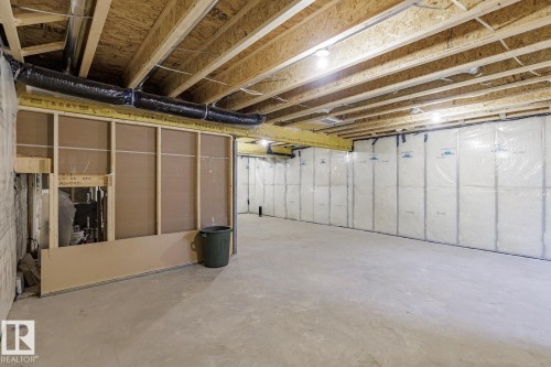 Unfinished basement featuring exposed wood joists, concrete flooring, insulated walls, and visible ductwork - 6308 65 Avenue, Beaumont, AB 