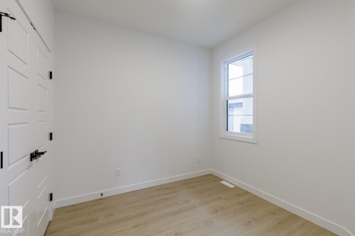 Room featuring light wood-finish flooring and white walls - 6308 65 Avenue, Beaumont, AB 