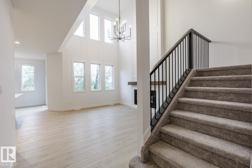 Carpeted staircase with black wrought iron balusters and handrail - 6308 65 Avenue, Beaumont, AB 