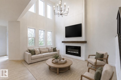 Spacious living area featuring a vaulted ceiling and an abundance of natural light from multiple windows - 6308 65 Avenue, Beaumont, AB 