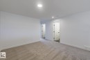 Spacious room featuring neutral carpet flooring, recessed lighting, white walls, and bright white trim - 6308 65 Avenue, Beaumont, AB 