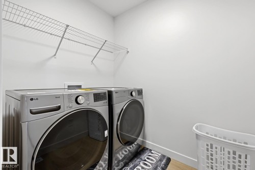 Laundry area with light-colored walls and wood-finish flooring - 22924 82 Ave, Edmonton, AB 