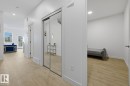 Light wood-finish flooring extends through this space, featuring white walls and recessed lighting - 22924 82 Ave, Edmonton, AB 