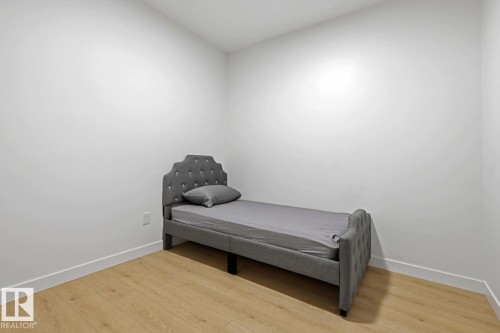 Room featuring neutral wall tones, wood-finish flooring, and white baseboards - 22924 82 Ave, Edmonton, AB 